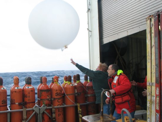 Lou Verstraete and Gary Granger launch a radiosonde balloon in rough conditions during the CLIMODE cruise of the R/V Knorr on the North Atlantic ocean.