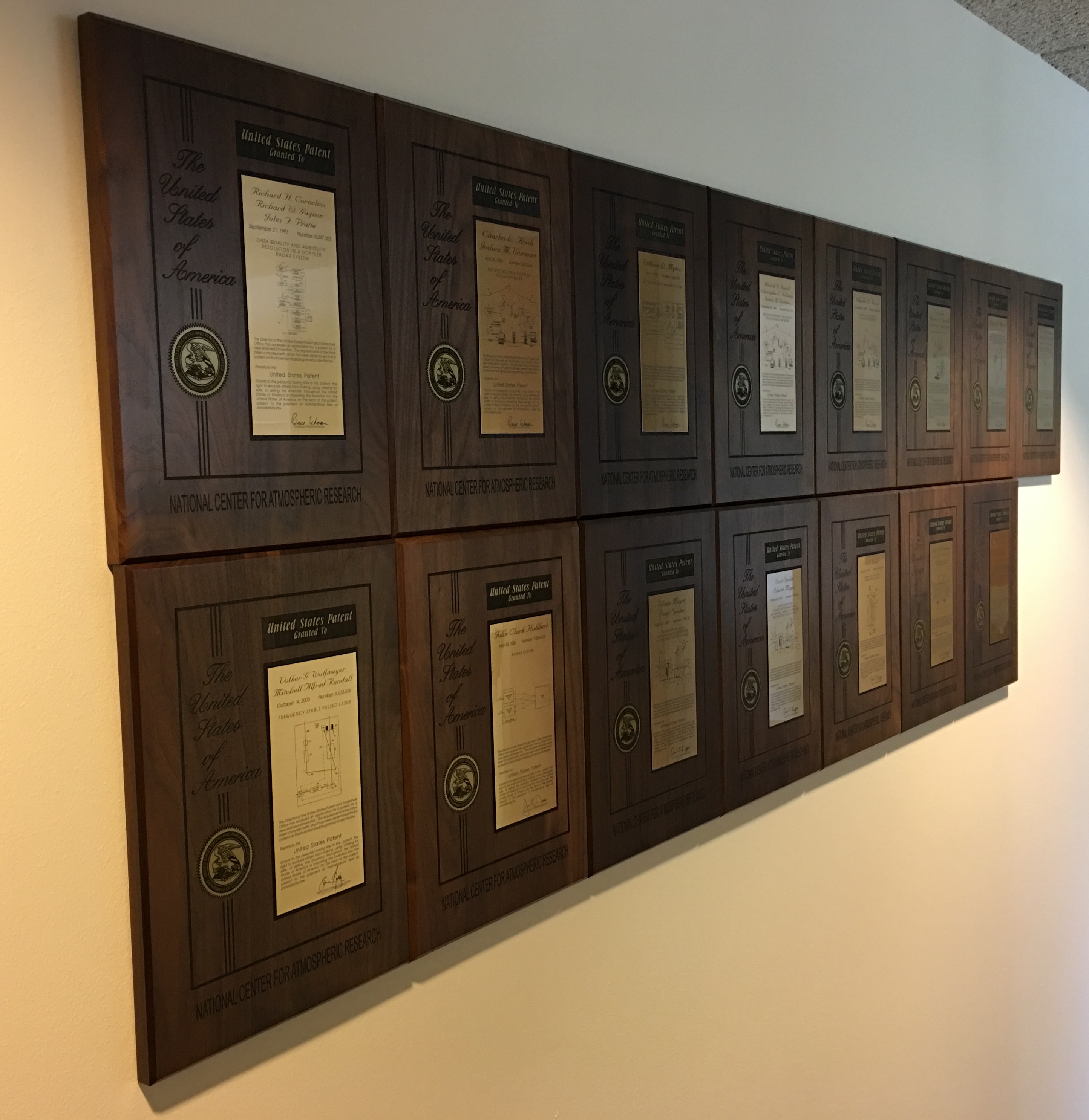 Many patent placards hanging on the wall.