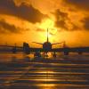 Airplane on runway at sunset.