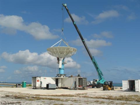 Crane moving large piece of equipment.