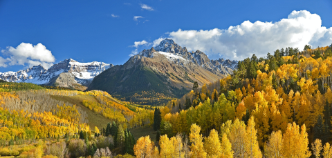 Mountain landscape in autumn with orange and yellow trees.